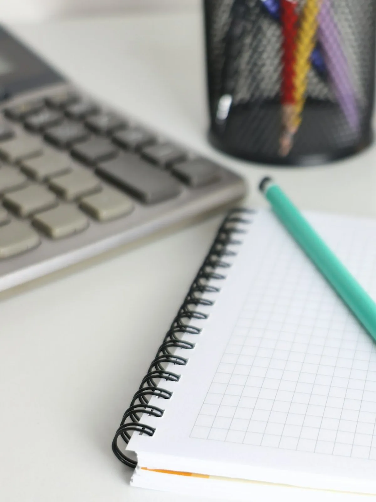 Notebook, calculator and pencil on a tidy desk